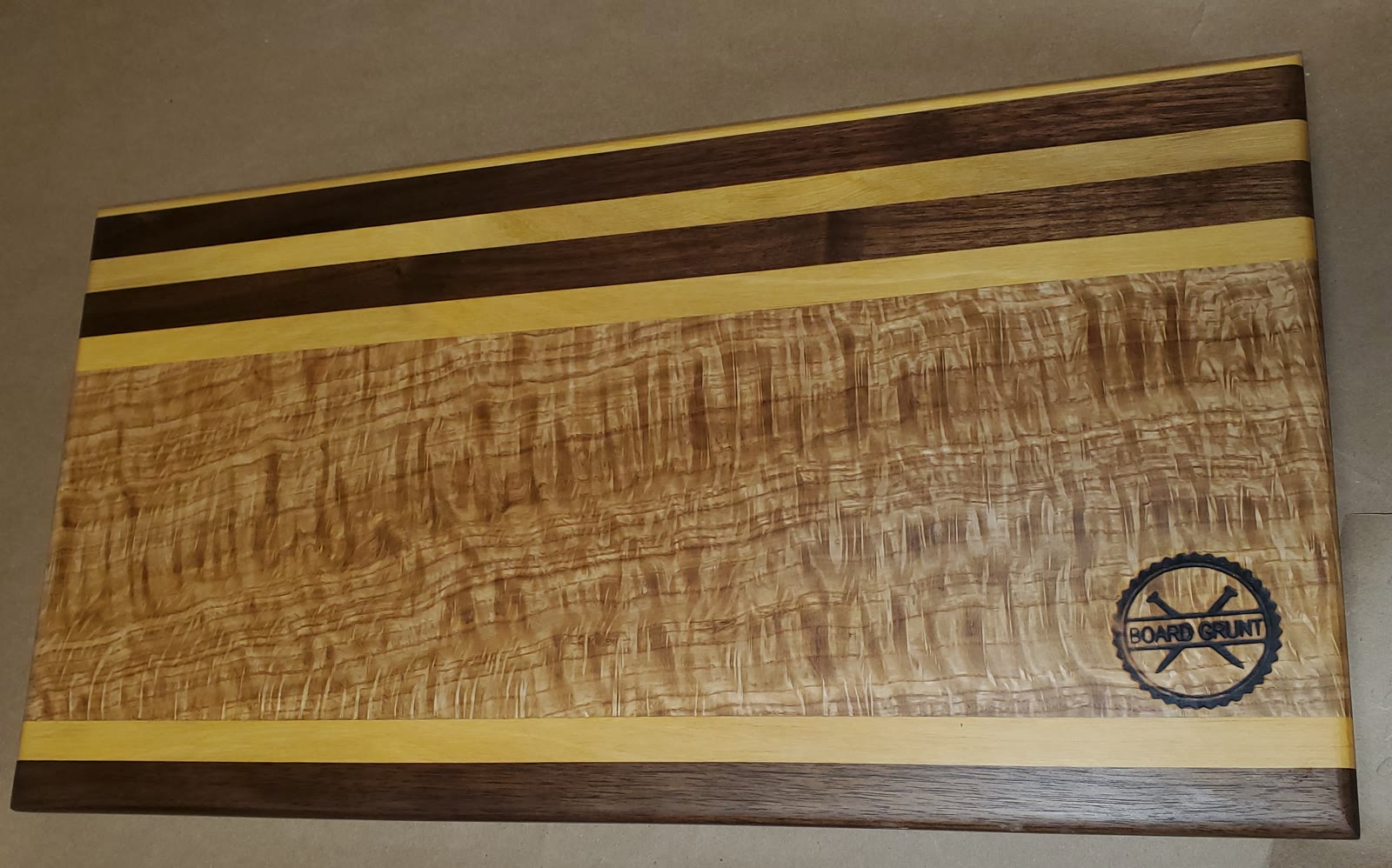 Striped hardwood cutting board with curly maple